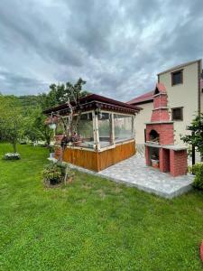 a house with a brick fireplace in a yard at Vinland Villa Atalar in Trabzon