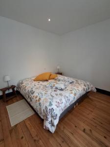 a bed in a room with a white wall at La maison de Lau in Salies-de-Béarn