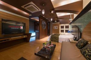 a hotel room with a bed and a flat screen tv at ホテルルアン横浜 in Kikuna +7 photos
