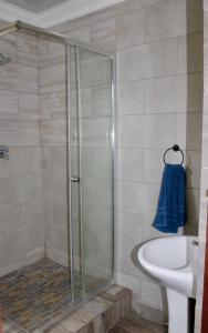 a bathroom with a shower and a sink at Saints boutique lodge in Bloemfontein +15 photos