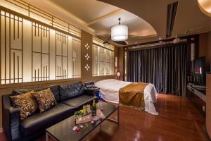 a living room with a couch and a bed at ホテルルアン横浜 in Kikuna