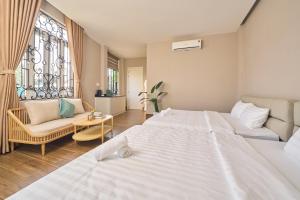 a bedroom with a bed and a couch and a window at Minh Nhat Villa - 3S Villa in Cồn Giả Viên