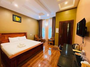 a hotel room with a bed and a television at Green Island Bungalows in Kampot