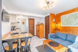 a living room with a blue couch and a table at Le Chalet des 3 Monts in Les Clefs