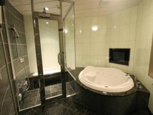 a bathroom with a shower and a bath tub at ホテルルアン横浜 in Kikuna