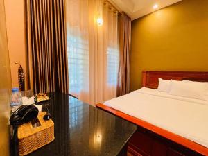 a bedroom with a bed and a desk with a phone at Green Island Bungalows in Kampot