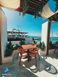 a table and chairs on a patio with a view of the ocean at نادي البحارة الدولي - International Seamans Club in Suez