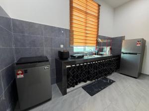a kitchen with a sink and a refrigerator at Homestay Aydan at Kijal Kemaman in Cukai +23 photos
