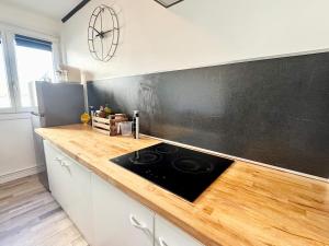 a kitchen with a stove and a blackboard on the wall at Chez Mamie Cloclo in Calais