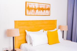 a bedroom with a bed with a wooden headboard and two lamps at 7th Heaven Apartments in Gaborone +21 photos