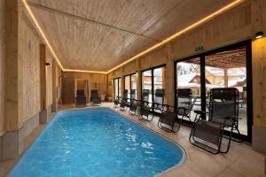 a swimming pool with chairs in a building at Casa Ambra in Sadova