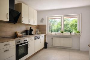 a kitchen with white cabinets and a window at Ferienwohnung Westerwaldblick großzügige Wohlfühloase mit Terrasse in Oberelbert