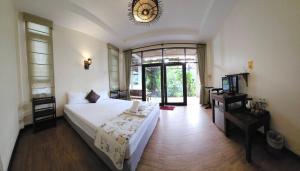 a bedroom with a bed and a window and a clock at The Mangrove Hideaway Kohchang in Ko Chang
