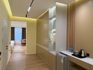 a hallway with a room with a bed and a kitchen at Golden Valley Hotel in Tashkent