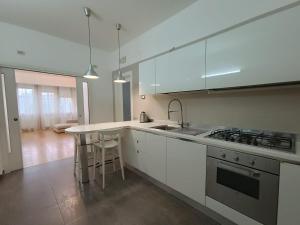 a kitchen with white cabinets and a sink and a stove at Suite Del Redentore 44 in Caserta