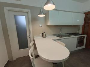 a kitchen with white cabinets and a white table at Suite Del Redentore 44 in Caserta +17 photos