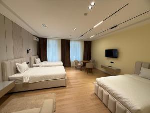 a hotel room with two beds and a table at Golden Valley Hotel in Tashkent