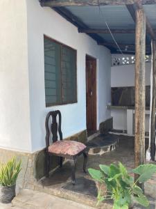 a chair sitting outside of a house at Petcat Cottage in Diani Beach