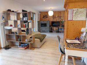 a living room with a bed and a desk in a room at Le chalet de cathy in Soultzeren