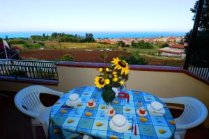 a table with a vase of sunflowers on a balcony at Appartamenti Del Sole in Tropea