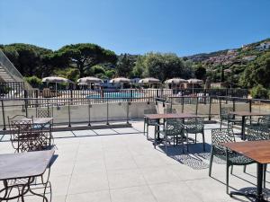 an outdoor patio with tables and chairs and umbrellas at Camping La Provençale - Maeva in Mandelieu-La Napoule