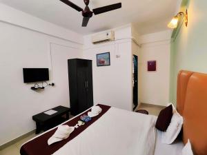 a bedroom with a white bed with a ceiling fan at Samudrasneha Resort in Nagaon