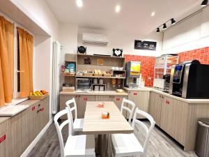 a kitchen with a wooden table and white chairs at Vatican Relais Rome Suite in Rome