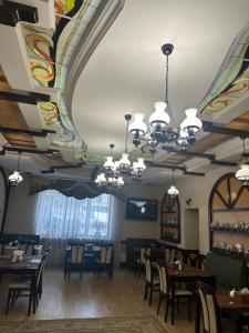 a dining room with a ceiling with a mural at Hotel&Restaurant SENATOR in Truskavets