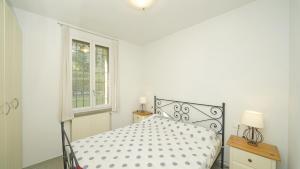 a white bedroom with a bed and a window at Garda Prestige Retreat in Moniga +40 photos