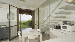 a white kitchen with a table and a microwave at Garda Prestige Retreat in Moniga
