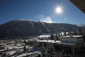 una vista su una montagna con il sole nel cielo di New renovated apartment in center of Davos a Davos