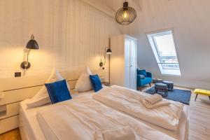 a bedroom with a large white bed with blue pillows at K94 Fischerhaus in Greetsiel