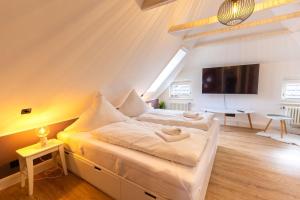 a bedroom with two beds and a flat screen tv at K94 Fischerhaus in Greetsiel