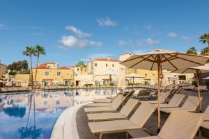 a swimming pool with lounge chairs and an umbrella at GF Isabel in Adeje