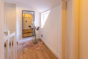 a hallway with a mirror and a vase with a plant at K94 Fischerhaus in Greetsiel +27 photos