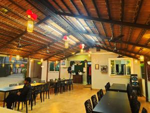 a person sitting at a table in a restaurant at Samudrasneha Resort in Nagaon
