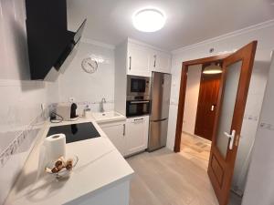a kitchen with white cabinets and a counter top at Puertas del Mar 1 in Puerto Real