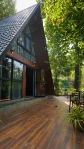 a house with a wooden deck in front of it at Lostcabins in Vallikavungal