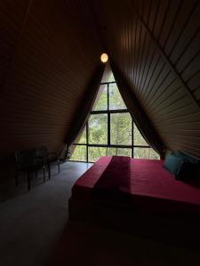 a bedroom with a large window in a tent at Lostcabins in Vallikavungal