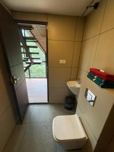 a small bathroom with a toilet and a sink at Lostcabins in Vallikavungal +46 photos