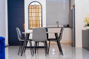 a kitchen with a table and four chairs at 7th Heaven Apartments in Gaborone