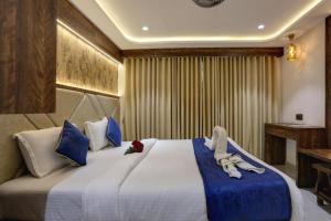 a bedroom with a large bed with blue and white pillows at Ramya Residency Navi Mumbai in Navi Mumbai