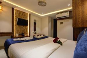 a hotel room with two beds and a television at Ramya Residency Navi Mumbai in Navi Mumbai