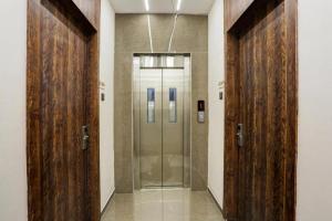 a hallway with two wooden doors in a building at Ramya Residency Navi Mumbai in Navi Mumbai +75 photos