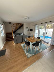 a living room with a wooden table and chairs at Ocean Whisper in Plettenberg Bay +7 photos