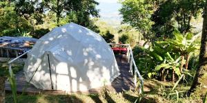 a white tent sitting on a wooden deck at Glamping Eco Azulejo in Arbeláez
