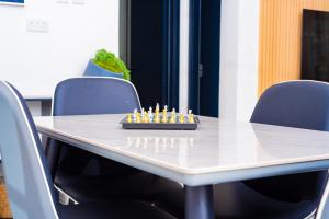 a chess board sitting on top of a table with chairs at 7th Heaven Apartments in Gaborone