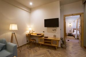 a living room with a tv and a desk and a couch at essence AT LADAKH in Leh