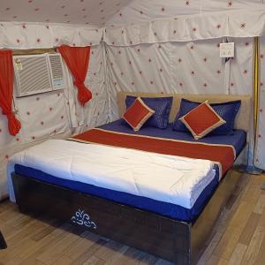 a bed in a tent with pillows on it at Down Valley Resort in Rishīkesh