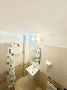 a bathroom with a sink and a mirror at Hotel Promenada in Mamaia +43 photos